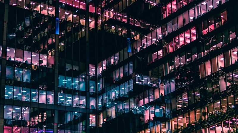 Beleuchtete Bürofenster eines Gebäudes bei Nacht